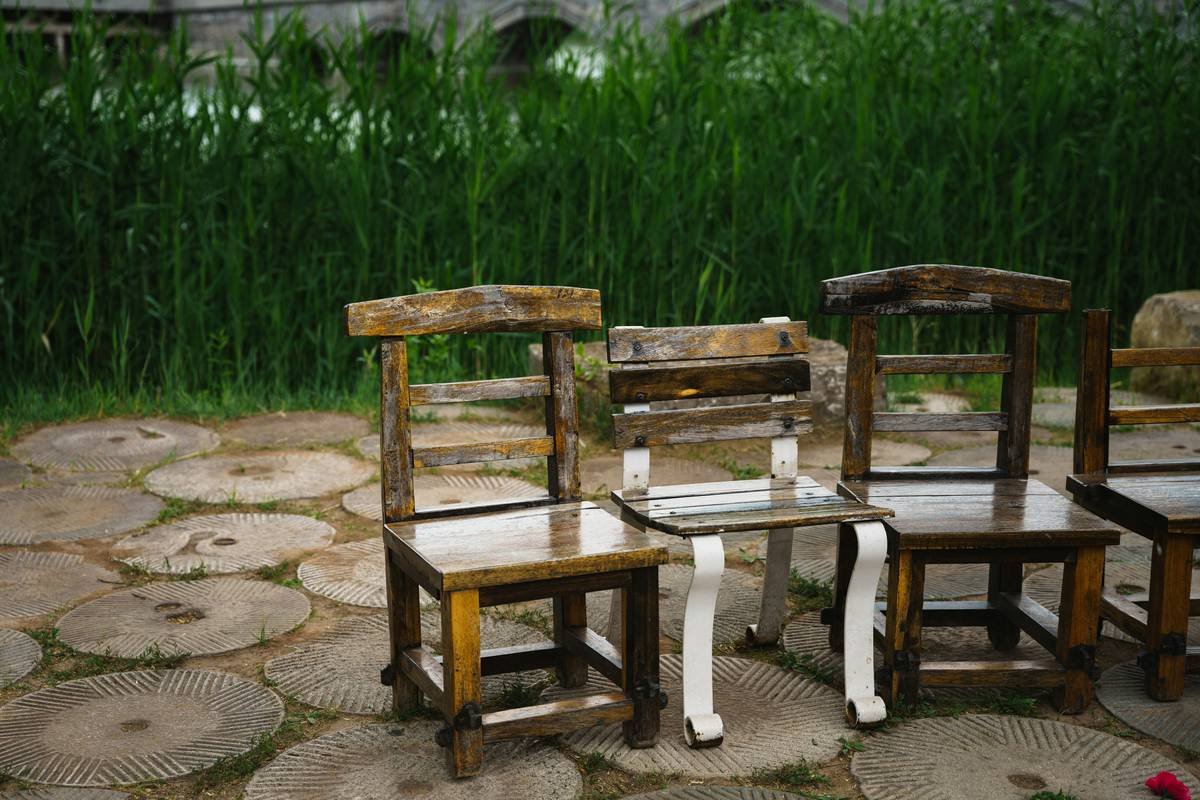 Diagram showing common failure points in DIY wood benches: water pooling under legs, cupped slats, cracked joints